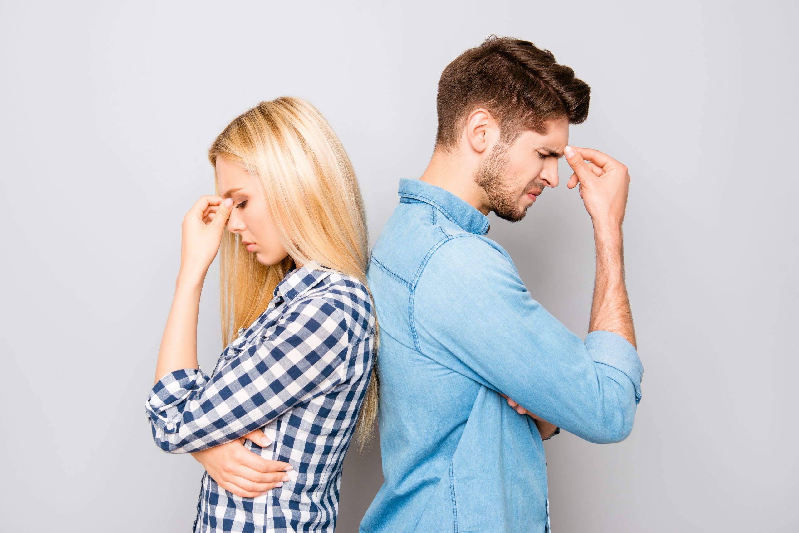カップルが頭を抱えて背中を向けている様子